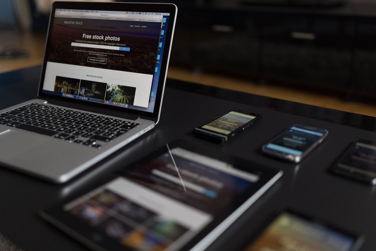 Un espace de travail contemporain présentant un ordinateur portable, une tablette et des smartphones, idéal pour un usage tech et freelance.
